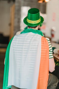 Back view of a man in festive attire celebrating St. Patrick's Day indoors.