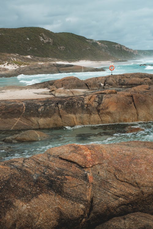 Rocky seacoast washed by azure stormy seawater