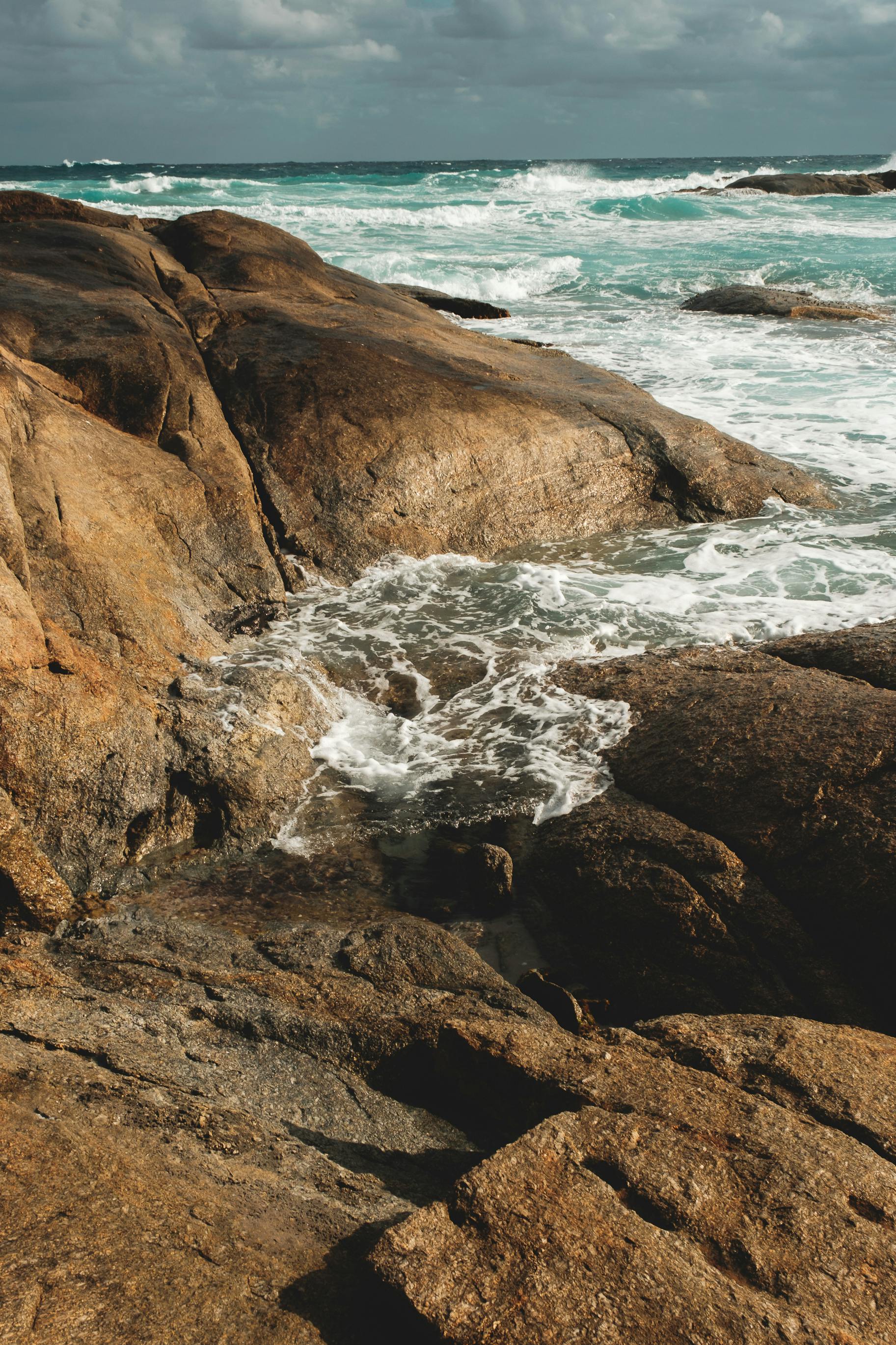 rough stony shore washed by azure seawater