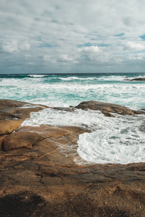 Azure sea waving on rough rocky coast