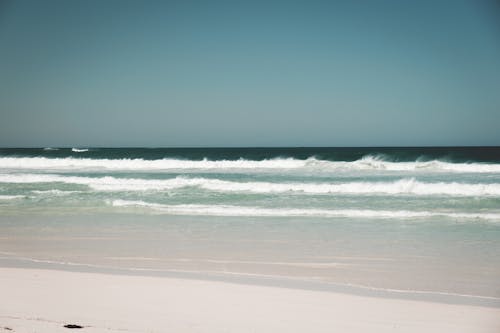 White sandy coast washed by foamy blue ocean