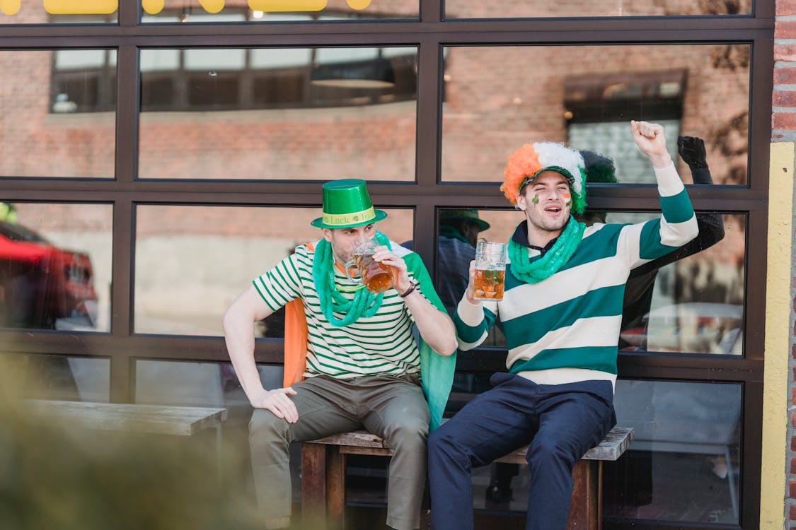 Joyful men drinking beer and yelling on street during national festival party