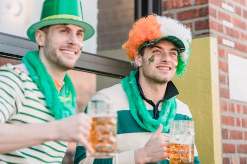 Free Happy men in traditional hats drinking beer during holiday Stock Photo