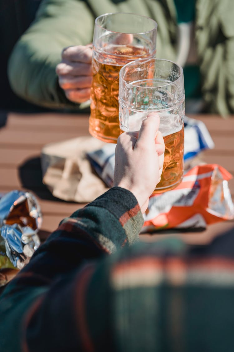 Unrecognizable Men Clinking Glasses Of Beer