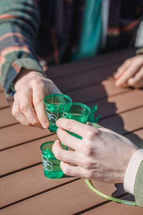 Crop friends drinking alcohol shots