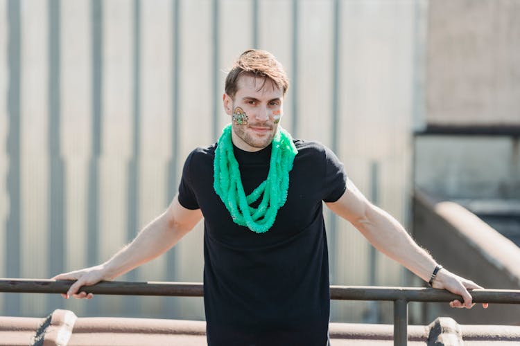 Smiling Young Guy With Painted Face Standing On Terrace On St Patricks Day