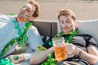 Exhausted drunk guys sleeping together on sofa after hangout