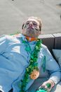 Drunk guy with shamrock accessories sleeping on sofa after party