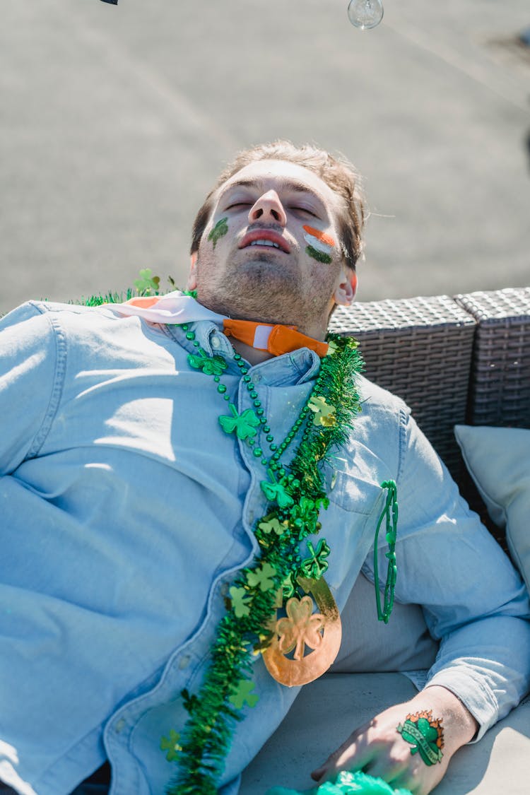 Drunk Guy With Shamrock Accessories Sleeping On Sofa After Party