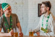Cheerful football fans drinking beer in pub and talking