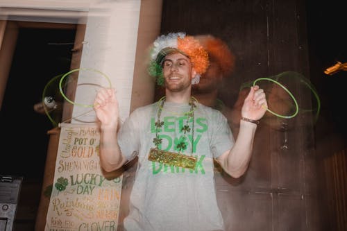 Positive young man dancing with neon glow stick necklace