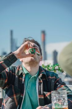 Young man drinking strong alcohol in terrace of pub