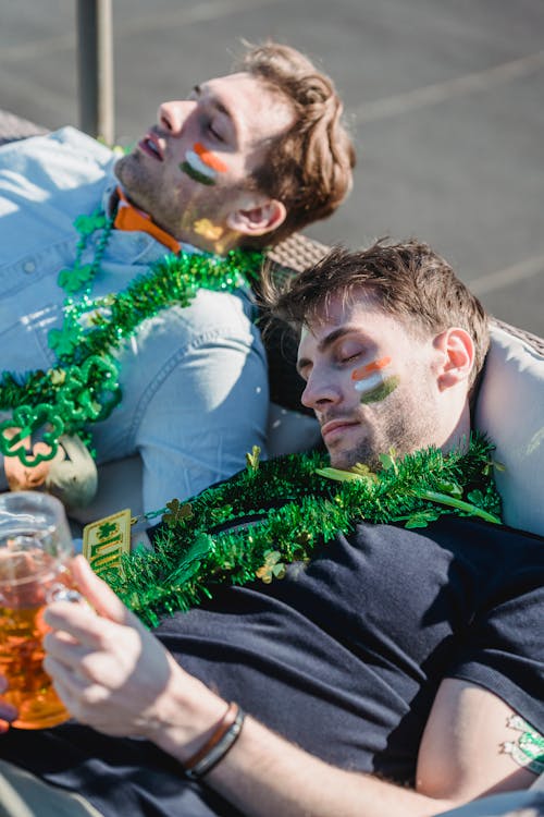 Free Football fans falling asleep with mug of beer in hand after party Stock Photo