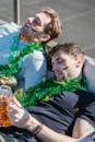 Football fans falling asleep with mug of beer in hand after party