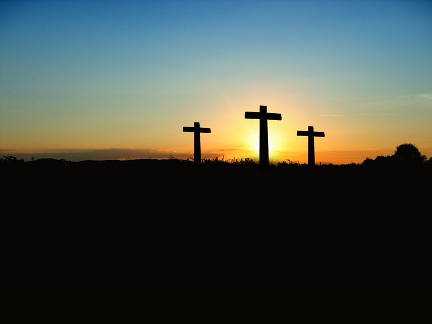 Silueta a trei cruci la apus de soare, simbol al credinței și spiritualității în visele românești
