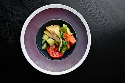 A Bowl of Fresh Fruits and Vegetables on a Wooden Table