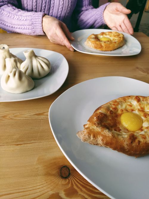 Free Close-up of Georgian khachapuri and dumplings on white plates, perfect gourmet delight. Stock Photo