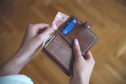 Close-Up Shot of a Person Holding a Brown Wallet