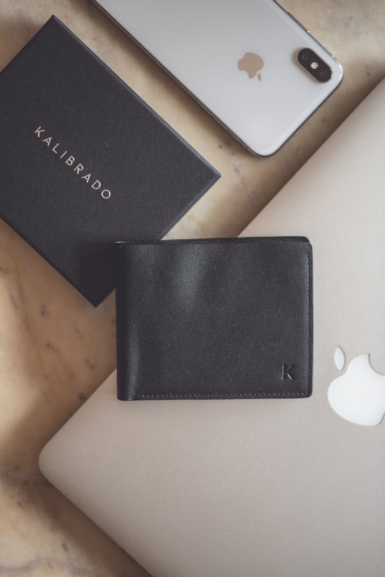 Black Leather Bifold Wallet On Top Of Macbook 