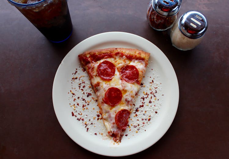 Sliced Pepperoni Pizza On White Ceramic Plate