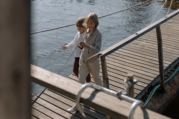 Children Walking On A Boardwalk