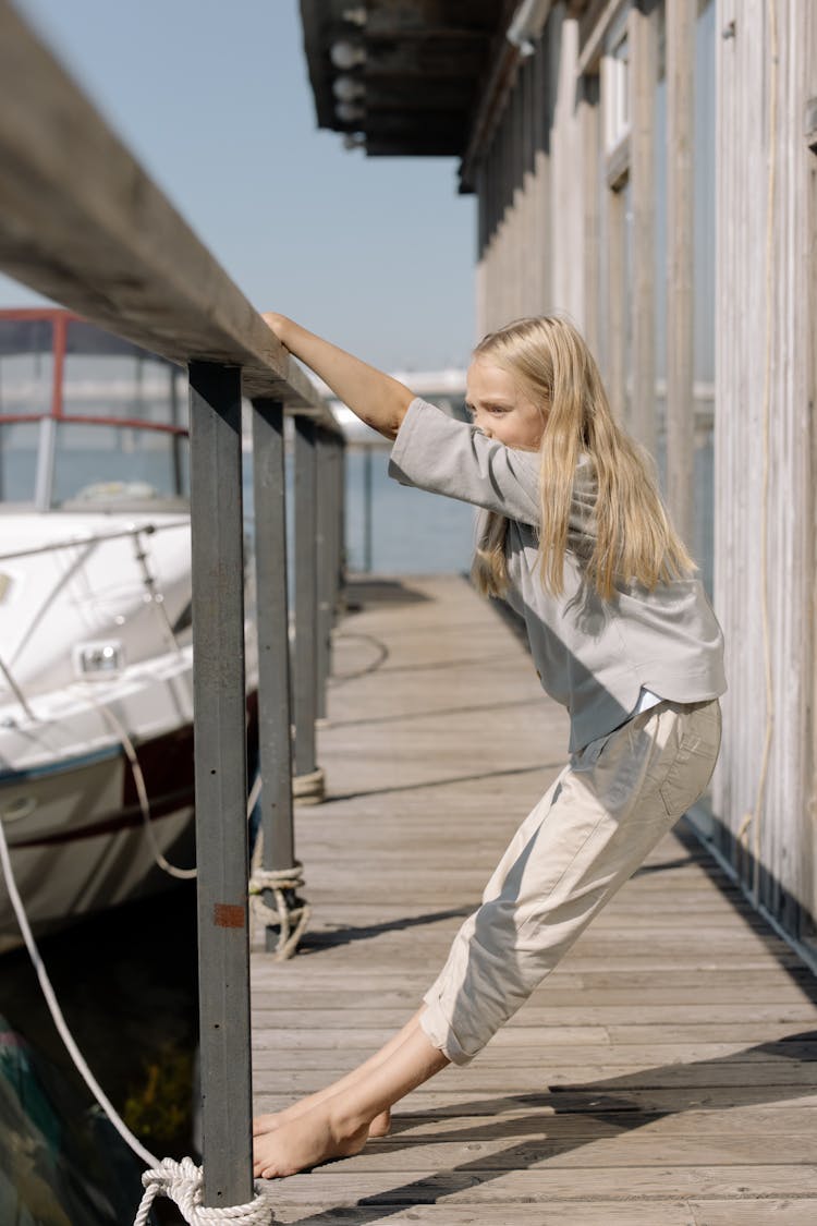 Girl Holding On A Wooden Banister