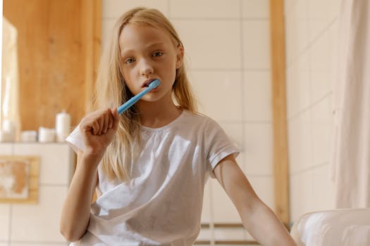 A young girl brushes her teeth, promoting daily dental care habits.