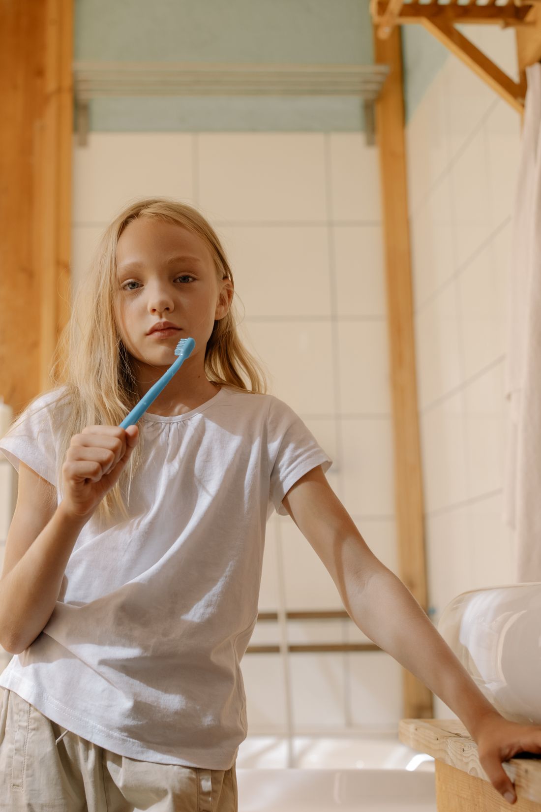 Bambina bionda con spazzolino durante l'igiene orale quotidiana