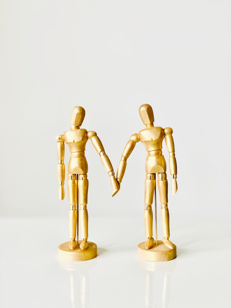 Close-Up Shot Of Gold Wooden Mannequins