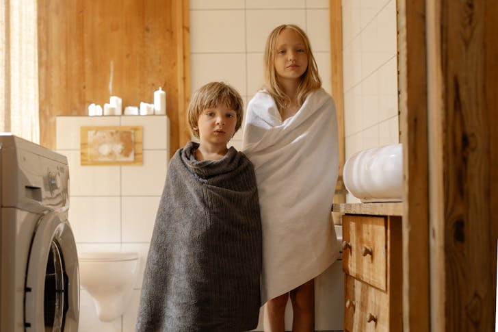 Two Kids Covered with Towels Standing in Bathroom