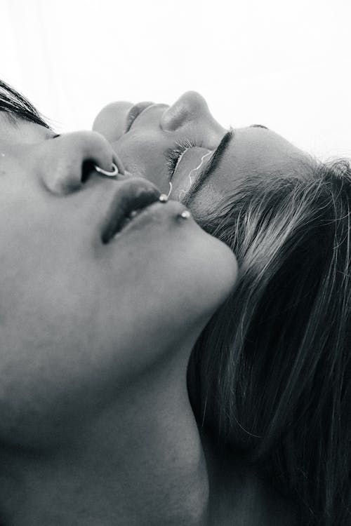 Free Grayscale Photo of Two Woman Lying Next to Each Other Stock Photo