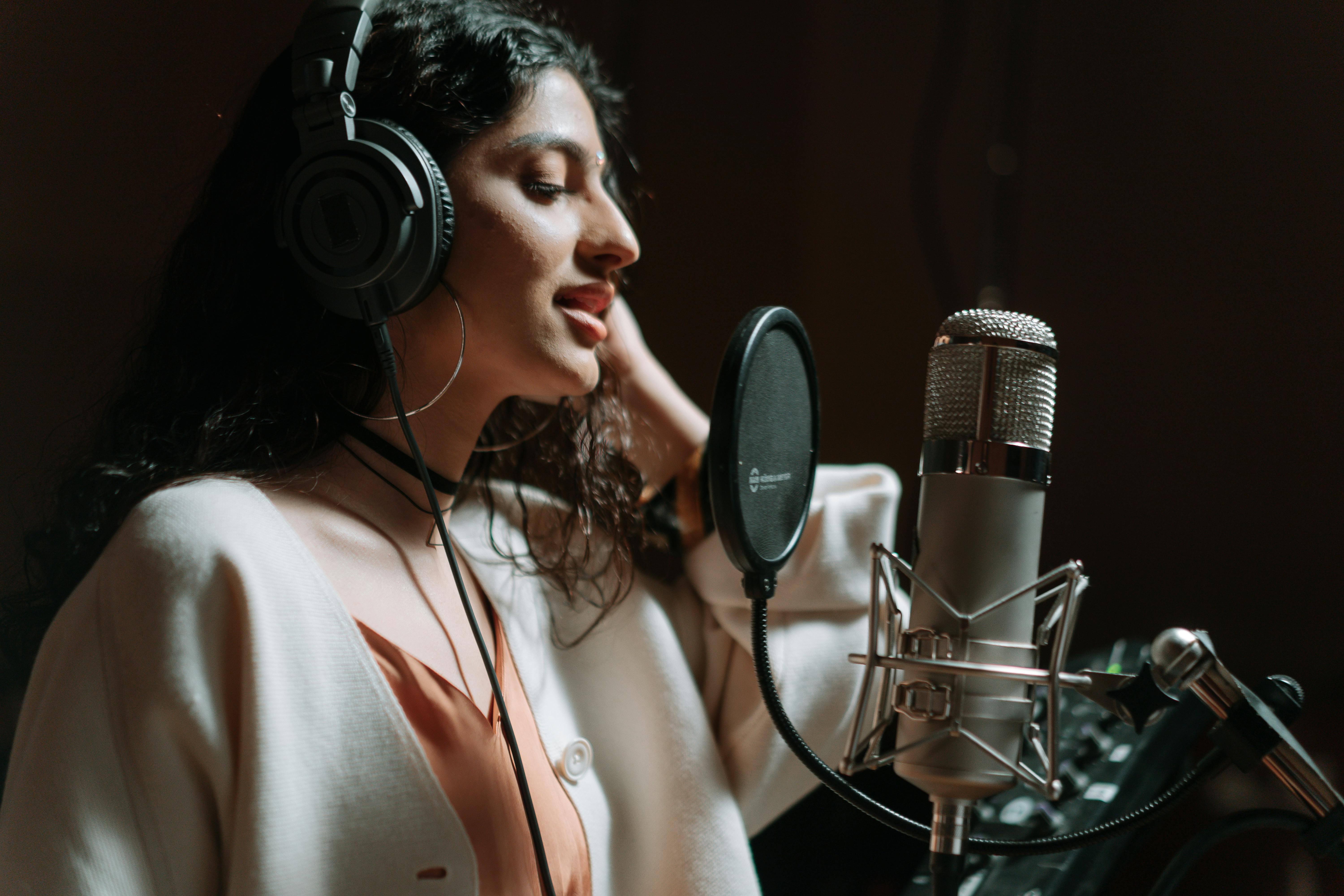 A person recording a song using a microphone