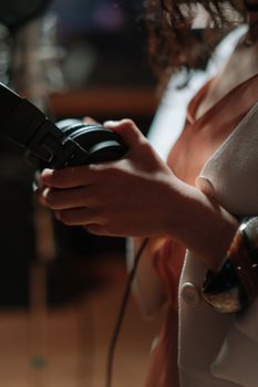A close-up of a woman holding headphones, indicating a focus on music or broadcasting.
