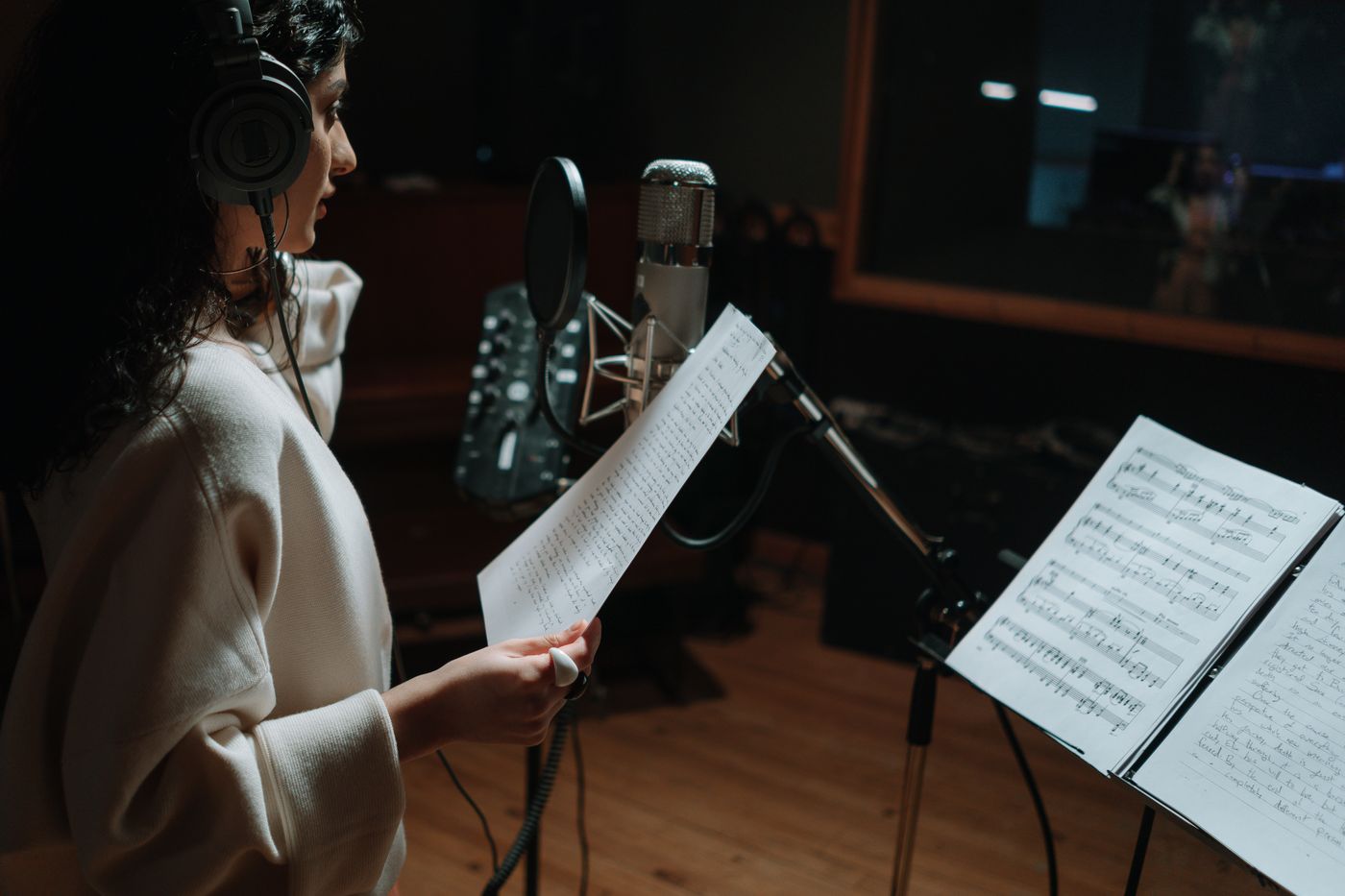 Artist recording vocals with a condenser microphone