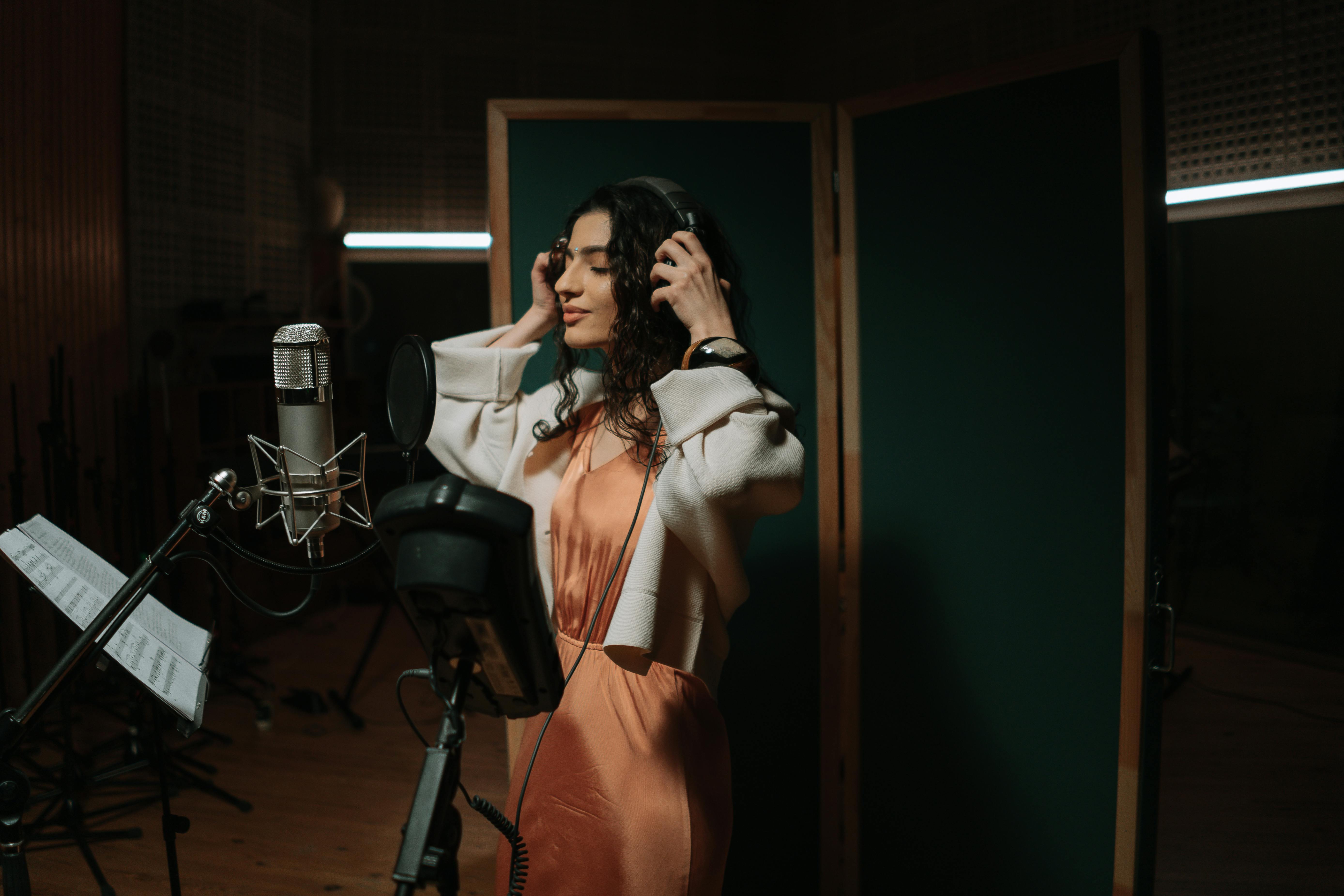 Woman in Orange Dress Standing Near Microphone · Free Stock Photo