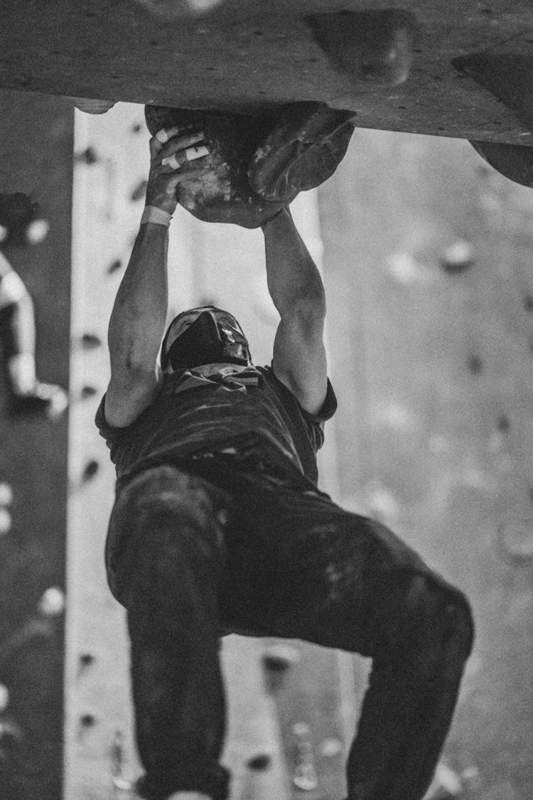 Grayscale Photo Of A Man Rock Climbing