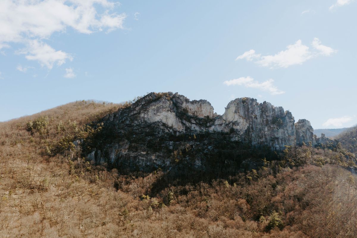 A dramatic fin of exposed rock rising above a forested mountain valley