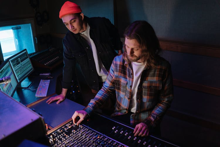 Men In The Recording Studio In Front Of The Mixing Board