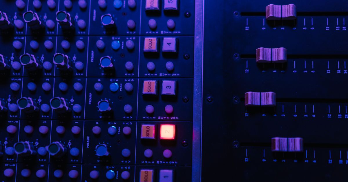 Close-up of a professional sound mixing board and LED screen inside a modern church auditorium