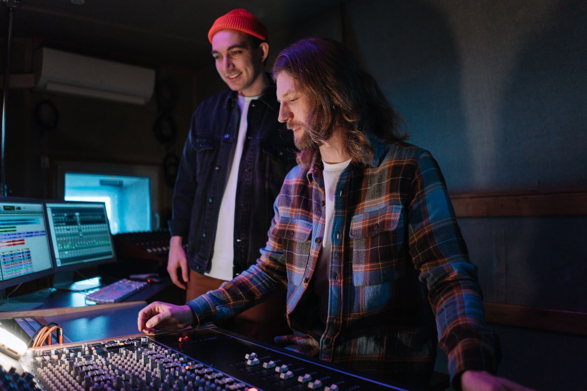 Two sound engineers collaborating in a music studio