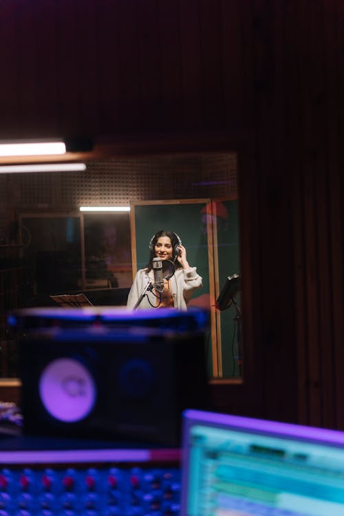 A Woman Wearing Headphones Inside the Music Studio