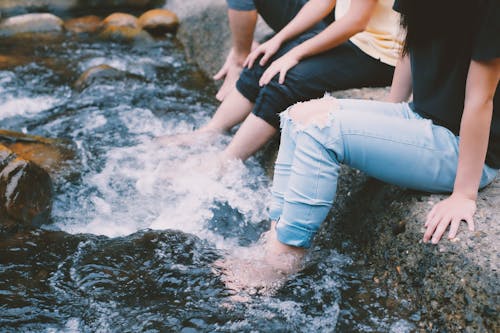 Menschen In Jeans Mit Füßen Im Wasser