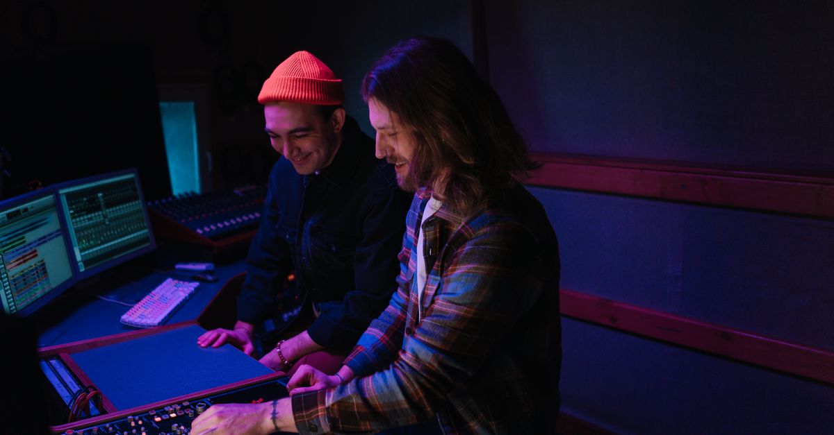 Volunteer team working on a soundboard and laptops in a modern church control room