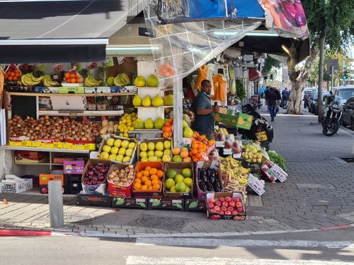 Free Street market with colorful fruits and vegetables on display in lively urban setting. Stock Photo