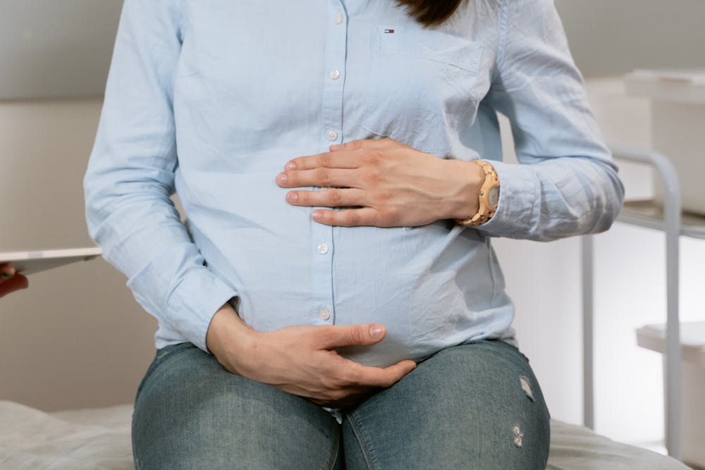 A pregnant woman holding her stomach. | Photo: Pexels