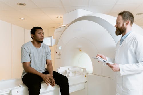 Free Photo Of Man Sitting On A CT Scanner  Stock Photo