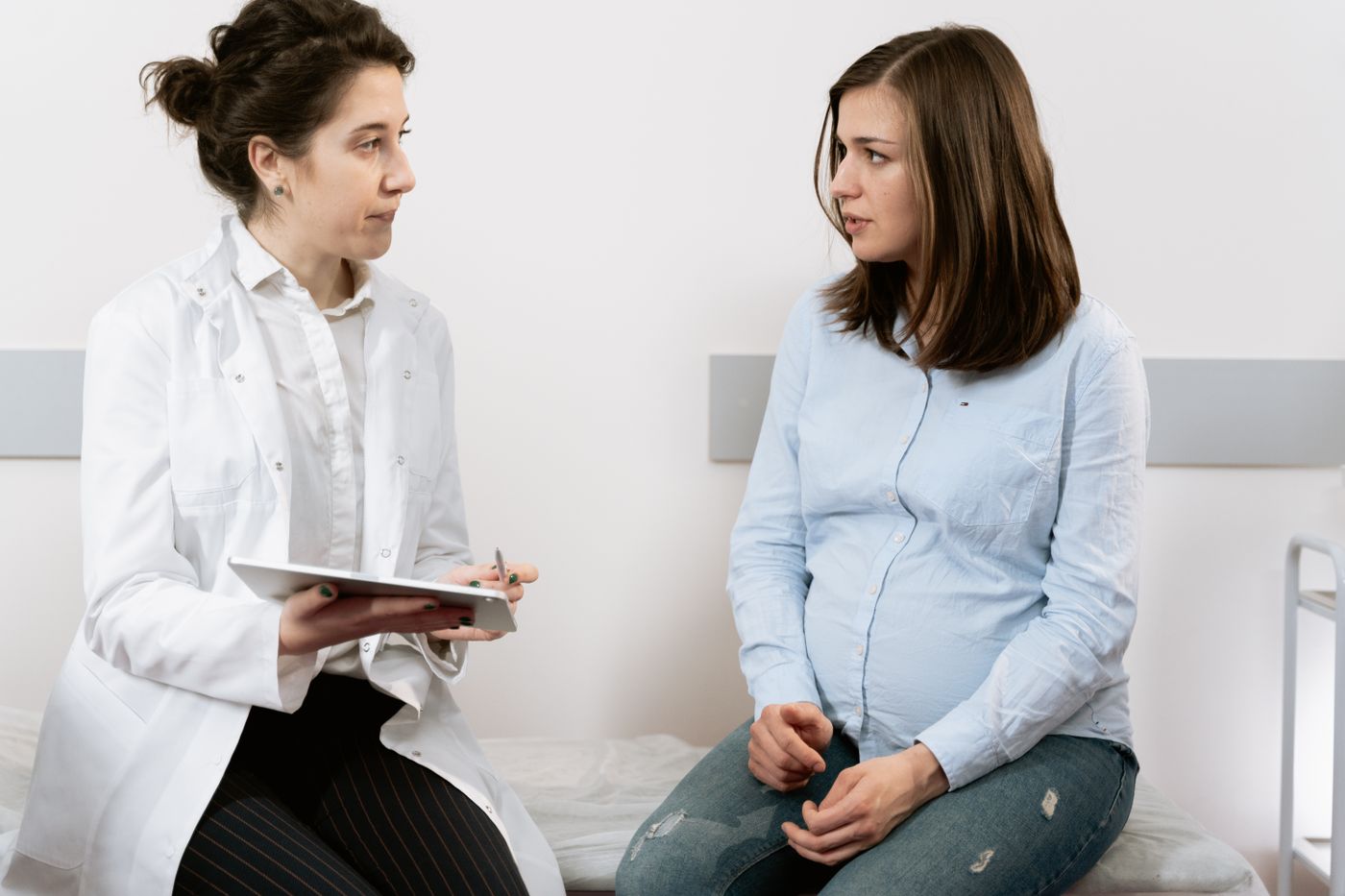Woman discussing menstrual and hormonal symptoms with a female medical specialist