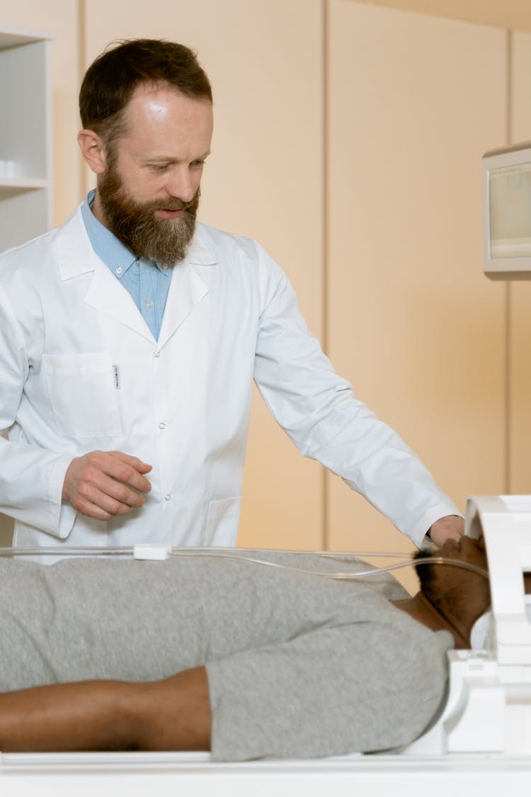 Photo Of Doctor Standing Beside Patient