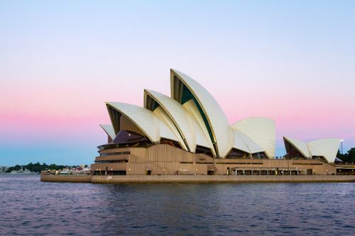 Free A stunning view of the Sydney Opera House with a colorful sunset sky in Sydney, Australia. Stock Photo