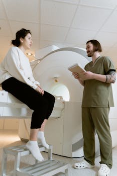 Healthcare worker and patient discussing MRI procedure in a hospital room.